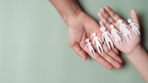 hands holding cut outs of a family