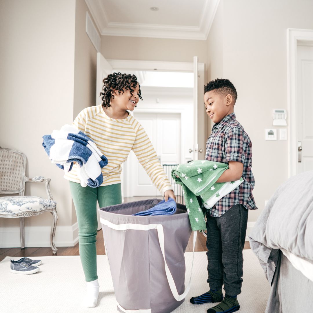 Two foster children doing laundry in a home. 